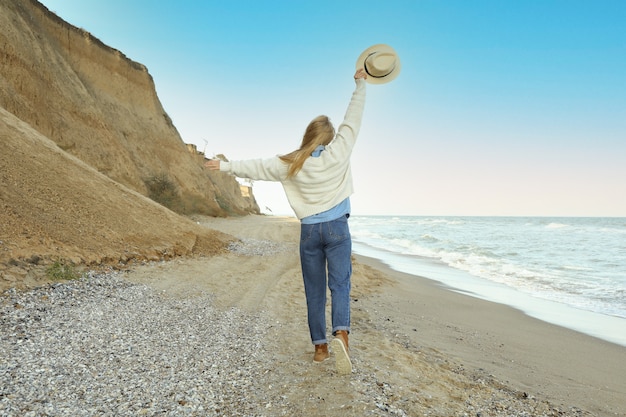 Hübsche junge Frau mit Hut am Sandstrand