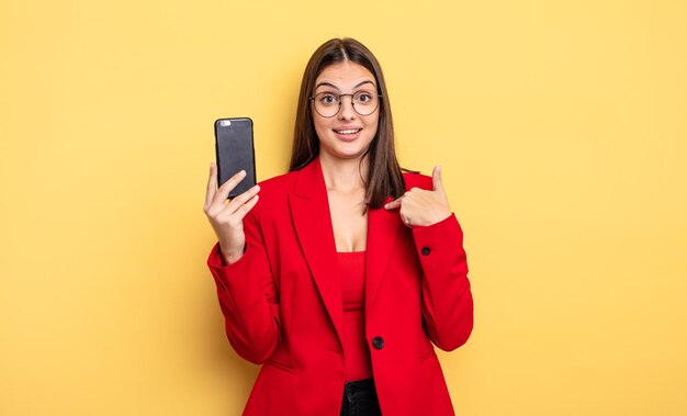 hübsche junge Geschäftsfrau, die ein Telefon hält