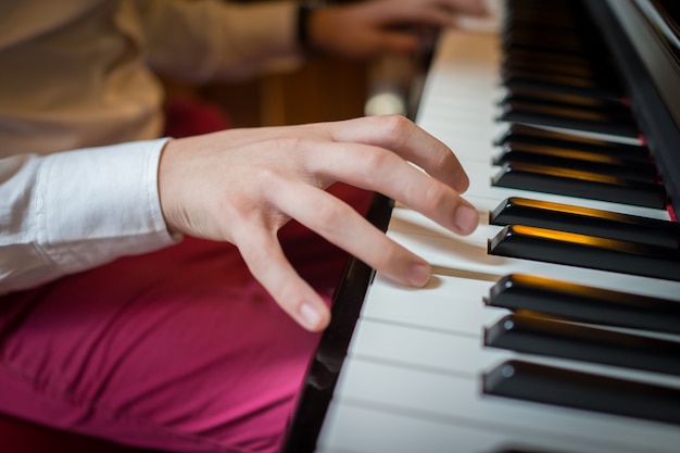 Hübsche junge Männer, die Klavier spielen und Musik machen