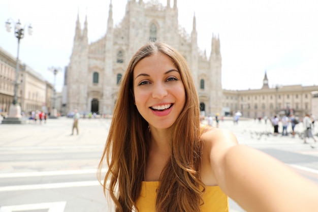 Hübsche junge Touristenfrau nimmt Selbstporträt auf dem Domplatz in Mailand, Italien.