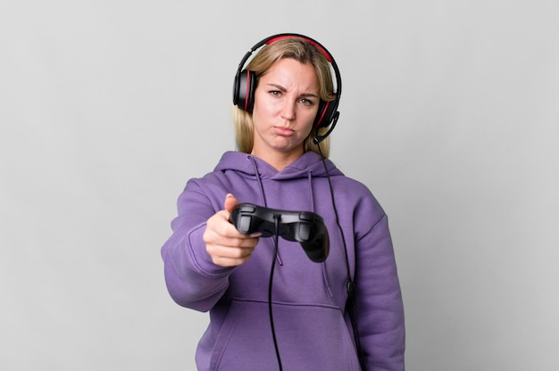 Foto hübsche kaukasische frau, die ein computerspiel mit kopfhörer und einem controller spielt