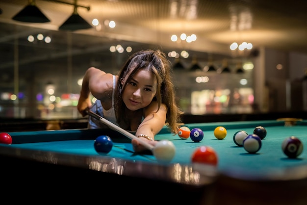 Hübsche kaukasische Frau, die im Pub Snooker spielt