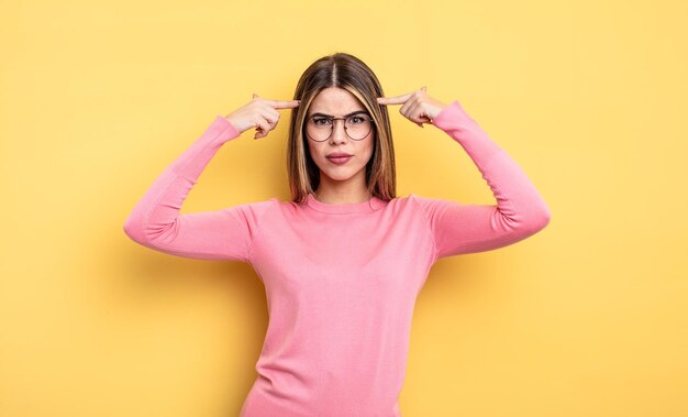 Hübsche kaukasische Frau mit ernstem und konzentriertem Blick, Brainstorming und Nachdenken über ein herausforderndes Problem