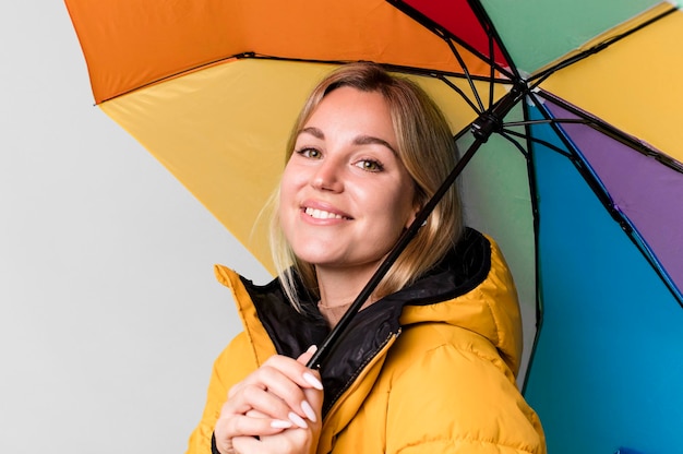 Hübsche kaukasische Frau mit Regenschirm und Anorak