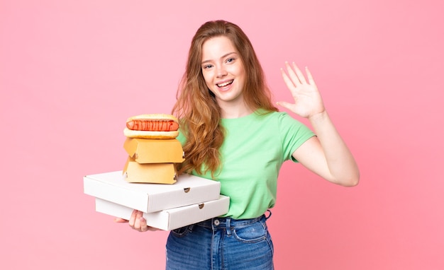 Hübsche rothaarige Frau, die Fast-Food-Boxen zum Mitnehmen hält