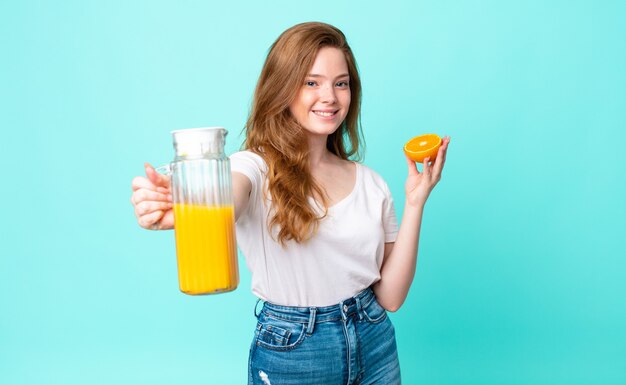 Hübsche rothaarige Frau. Orangensaft Konzept