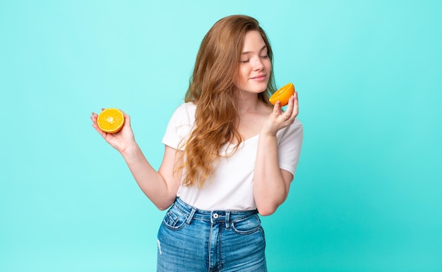 Hübsche Rotkopffrau. Orangensaft-Konzept