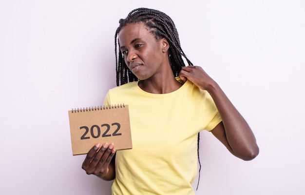 Hübsche schwarze Frau, die sich gestresst, ängstlich, müde und frustriert fühlt. Kalenderkonzept 2022