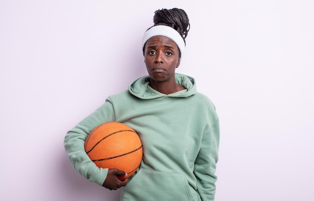 Hübsche schwarze Frau, die sich traurig und weinerlich mit einem unglücklichen Blick und Weinen fühlt. Basketball-Konzept