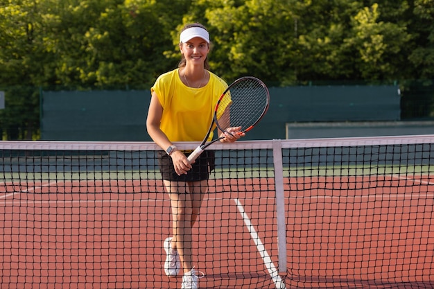 Hübsche Sportlerin mit Schläger am Tennisplatz Gesunder Lebensstil