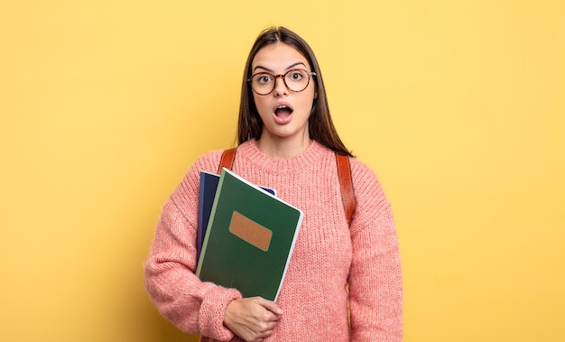 Hübsche Studentenfrau, die sehr schockiert oder überrascht aussieht