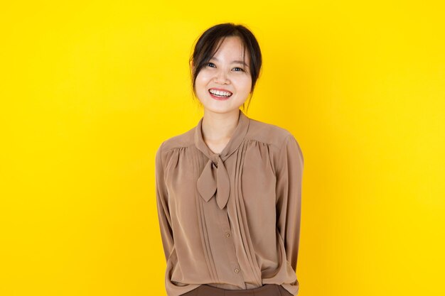 Hübsche und gesunde asiatische Frau lächelt und lacht freundlich mit unschuldigem, charmantem Gesicht als glücklich und genießt es, attraktive Kostümmode für schöne Bluse zu posieren. Nettes Mädchen drücken fröhliches Schönheitsmodell aus.