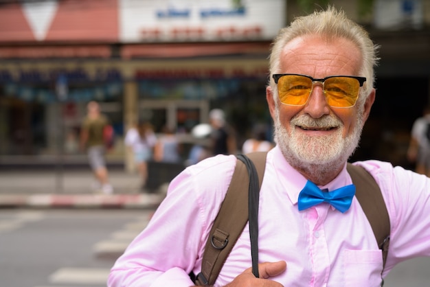 Hübscher älterer Touristenmann, der die Stadt Bangkok, Thailand erforscht