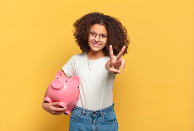 Hübscher Afro-Teenager, der schockiert, verängstigt oder verängstigt aussieht, das Gesicht mit der Hand bedeckt und zwischen den Fingern späht. Einsparungskonzept