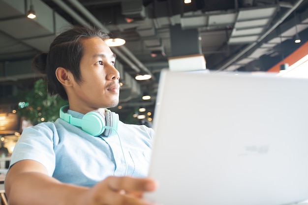Foto hübscher asiatischer mann, der laptop verwendet. start-business-konzept