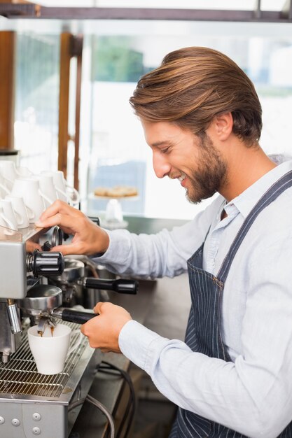 Hübscher Barista, der einen Tasse Kaffee macht