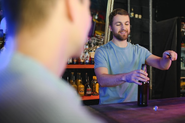 Hübscher Barkeeper, der hinter seiner Theke in einer Kneipe steht