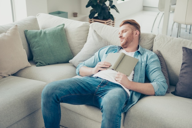 Hübscher blonder Kerl auf dem Sofa