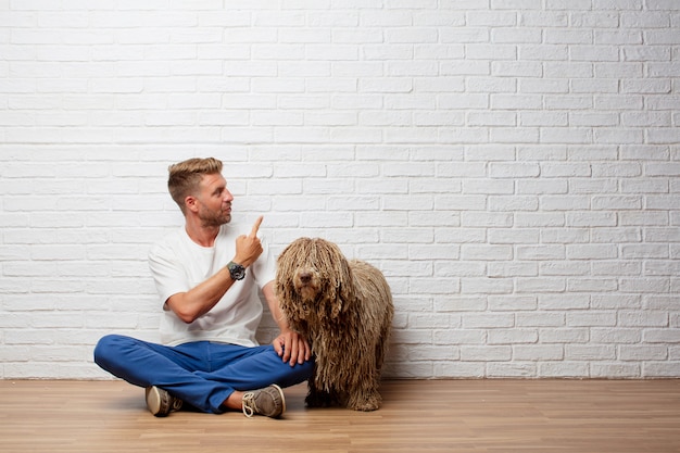 Hübscher blonder Mann mit einem Hund