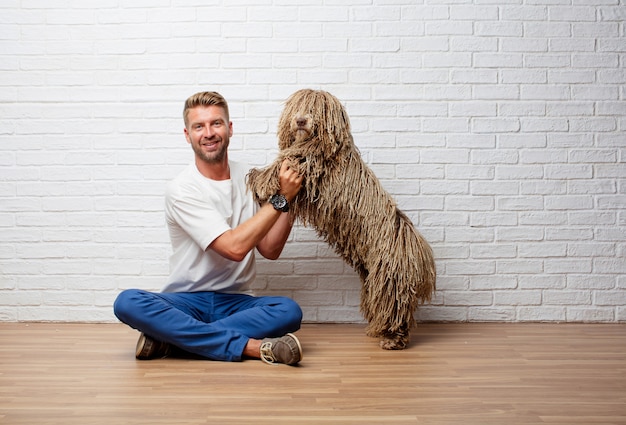 Hübscher blonder Mann mit einem spielenden und genießenden Hund