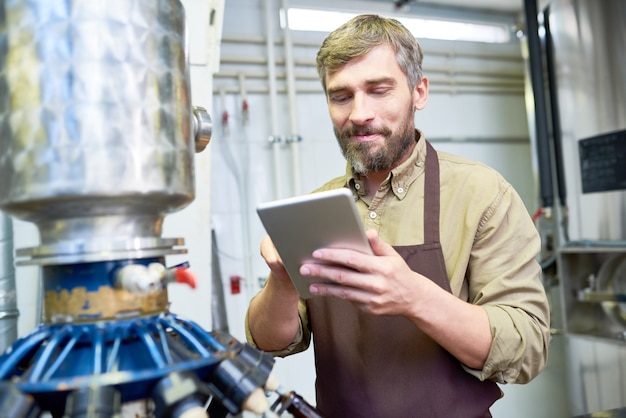 Hübscher Brauer mit digitalem Tablet