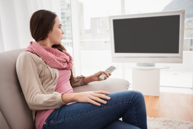 Hübscher Brunette, der auf Couch fernsieht