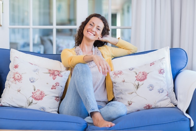 Foto hübscher brunette, der auf der couch sich entspannt