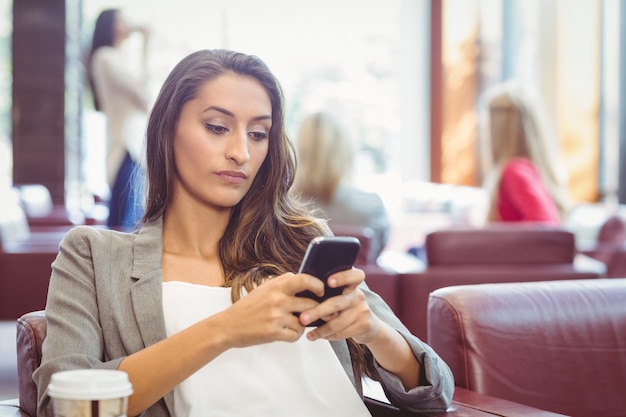 Hübscher Brunette, der den Kaffee sendet Text isst