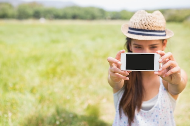 Hübscher Brunette, der ein selfie im Park nimmt