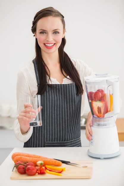 Hübscher Brunette, der einen gesunden Saft vorbereitet