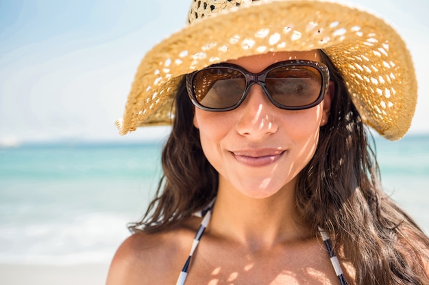 Hübscher Brunette, der Kamera auf den Strand betrachtet