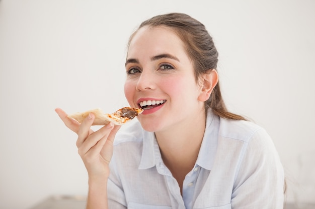 Hübscher Brunette, der Scheibe der Pizza isst