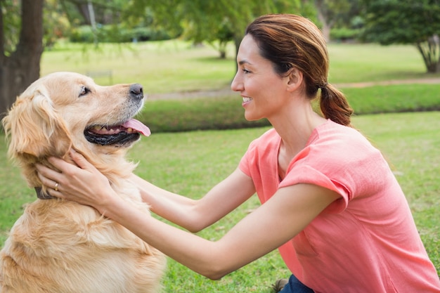 Hübscher Brunette mit ihrem Hund im Park