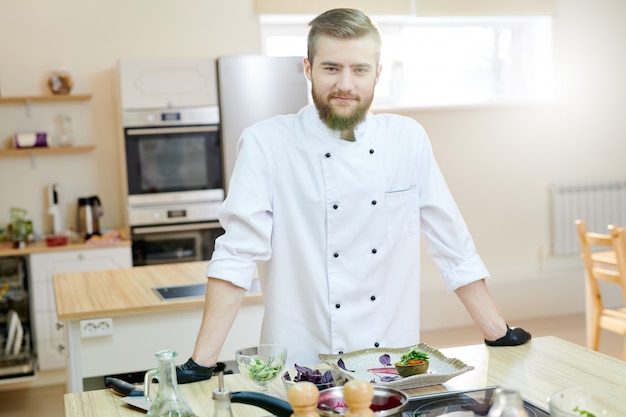 Hübscher Chef, der in der Küche aufwirft