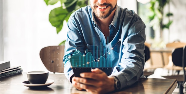 Hübscher, erfolgreicher Hipster-Mann, der sich mit einem digitalen Smartphone entspannt und den Bildschirmfortschritt des Geschäftsziels Finanzinvestitionsdatendiagramm und Diagramm des Geschäftswachstums im Café betrachtet