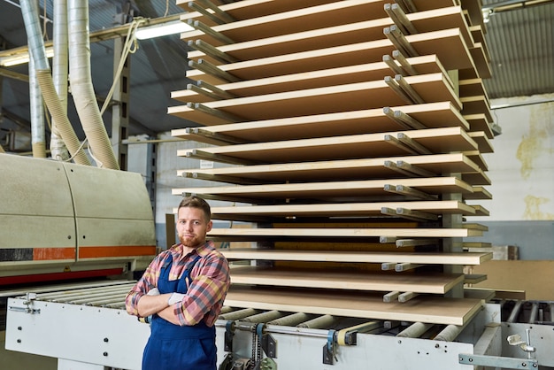 Hübscher Fabrikarbeiter, der in der Werkstatt aufwirft