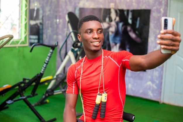 Hübscher Fitness-Enthusiast, der Selfie im Fitnessstudio macht