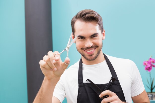 Hübscher Friseur, der an der Kamera lächelt