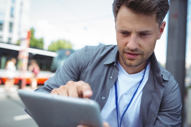 Hübscher Geschäftsleiter, der digitales Tablett verwendet