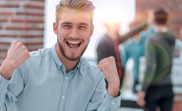 Hübscher Geschäftsmann, der den Sieg feiert, der glücklich in Th schreit