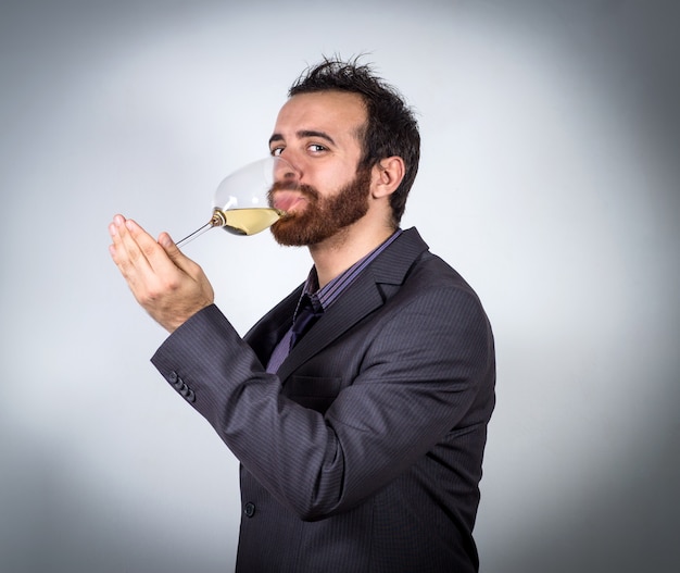 Hübscher Geschäftsmann, der ein Glas Wein hält