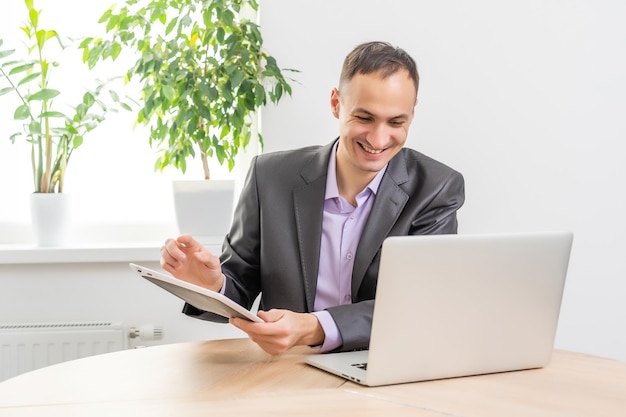 Hübscher Geschäftsmann, der mit Laptop im Büro arbeitet.