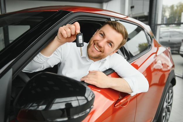 Hübscher geschäftsmann, der vor dem kauf auto fährt