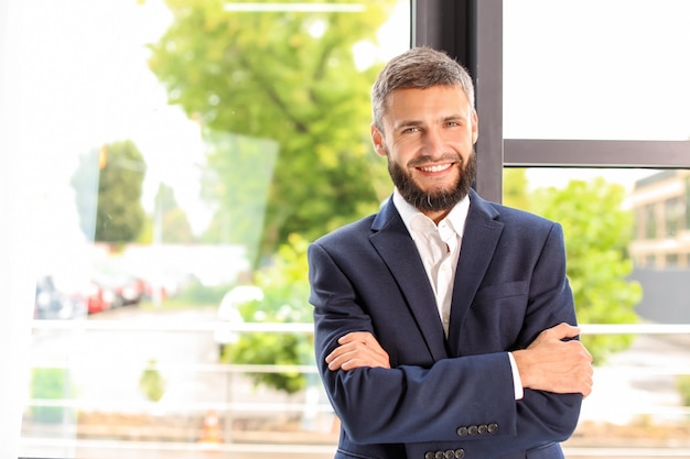 Hübscher Geschäftsmann nahe Fenster