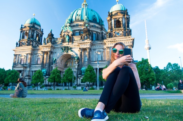 Hübscher Gil sitzt bei wunderschönem Sonnenuntergang vor dem Berliner Dom und macht Selfie