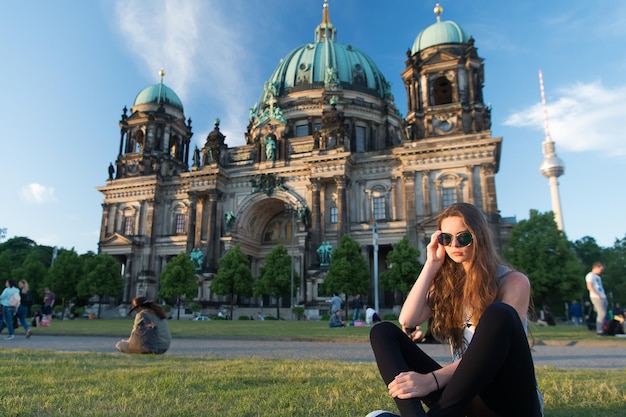 Hübscher Gil sitzt mit Sonnenbrille vor dem Berliner Dom bei wunderschönem Sonnenuntergang, entspannt und genießt das Leben