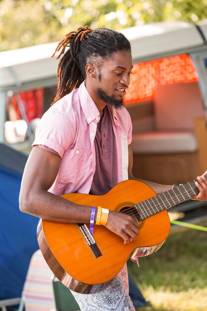 Hübscher Hippie, der die Gitarre spielt