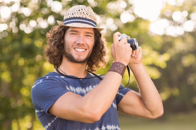 Hübscher Hippie, der Weinlesekamera verwendet