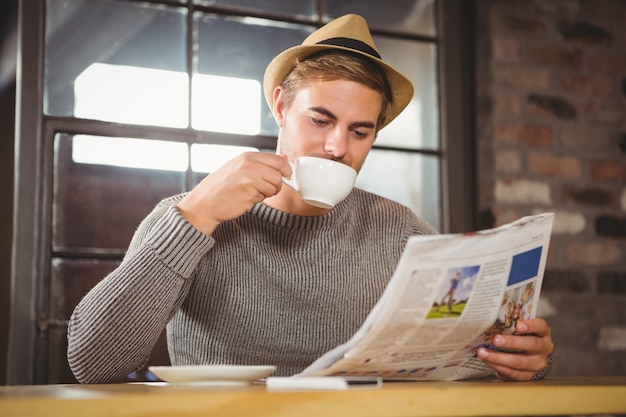 Hübscher Hippie Kaffee trinken und Zeitung lesen