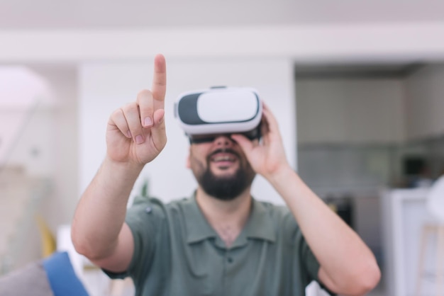 hübscher Hipster-Mann mit Bart, der eine VR-Brille im modernen Zuhause versucht